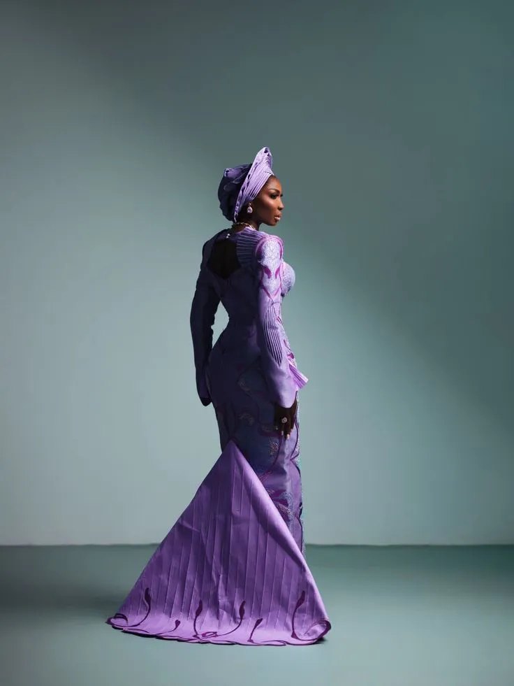 A bride in a purple gown with a matching gele